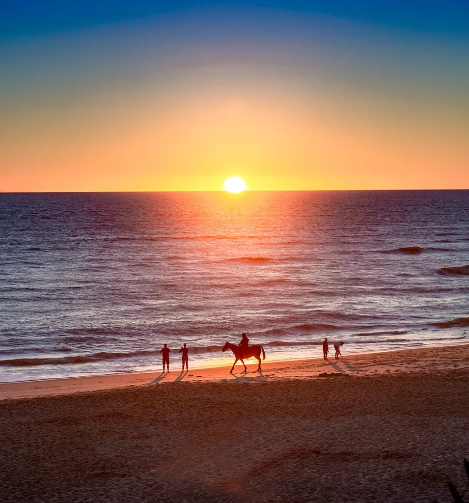 Promenade à cheval au coucher de soleil sur la plage